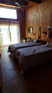 1 dormitorio con 2 camas y ventilador de techo en Casa de Montaña Valle Escondido en San Martín de los Andes