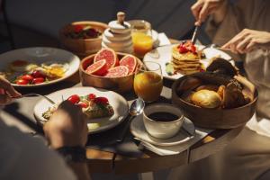 een tafel met borden met ontbijtproducten en -dranken bij Domes of Elounda, Autograph Collection in Elounda