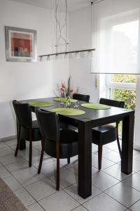 comedor con mesa negra y sillas en Ferienwohnung Bernhardt, en Lindau