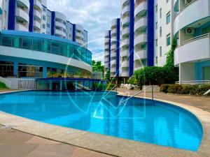 a large blue swimming pool in front of a building at Águas da Serra TURISMO in Rio Quente