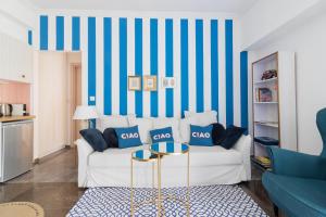 a living room with a white couch and blue and white stripes at Retropolitan Living Patras in Patra