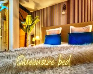 um quarto com uma cama grande e almofadas azuis em Apartment Duplex with Sauna City- Center Cathedrale em Estrasburgo