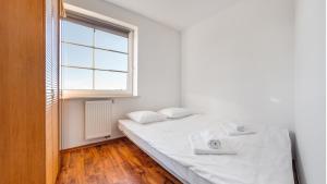 ブワディスワボボにあるApartamenty Sun & Snow Rzemieslniczaの白いベッドルーム(ベッド1台、窓付)