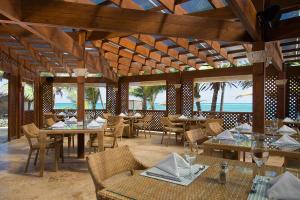 restauracja ze stołami i krzesłami oraz oceanem w obiekcie VIK Hotel Cayena Beach All Inclusive w Punta Cana