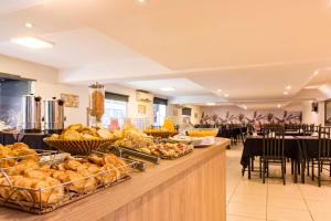 una línea de buffet con cestas de pan y mesas en Costanera Hotel en Villa Carlos Paz