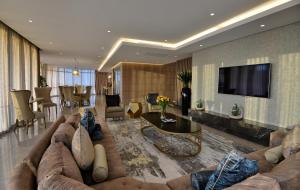 a living room with a couch and a tv at The Houghton Hotel, Spa, Wellness & Golf in Johannesburg