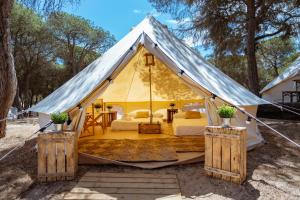 a tent with a bed and a table at Kampaoh Calella de Palafrugell in Calella de Palafrugell