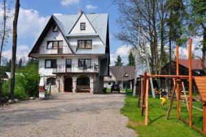 a large white house with a playground in front of it at Dom w Leśnicy in Leśnica