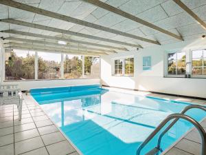 a large pool with blue water in a house at 8 person holiday home in Vejers Strand in Vejers Strand