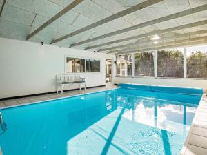 an indoor swimming pool with blue water in a house at 8 person holiday home in Vejers Strand in Vejers Strand