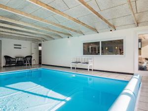 a swimming pool in a house with a table and chairs at 8 person holiday home in Vejers Strand in Vejers Strand