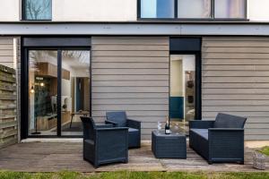 a patio with chairs and a table in front of a building at Chez Stéphane & Sophie - 10min DisneyLand, Free Parking, Big Garden in Montévrain