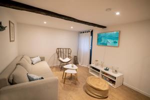 uma sala de estar com um sofá e uma cadeira em Villa Valentine em Veules-les-Roses