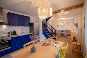 uma cozinha e sala de jantar com mesa e armários azuis em Villa Valentine em Veules-les-Roses