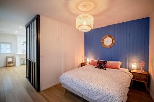 um quarto com uma cama e uma parede azul em Villa Valentine em Veules-les-Roses