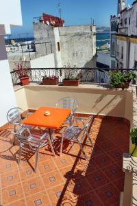 a table and chairs on a balcony with a view at Hotel Maram in Tangier
