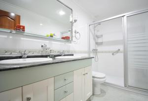 een witte badkamer met 2 wastafels en een douche bij Piso en pleno centro de Vilagarcía de Arousa in Vilagarcia de Arousa