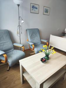 uma sala de estar com duas cadeiras e uma mesa de centro em Station street apartments em Sigulda
