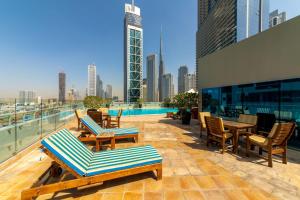 a rooftop patio with chairs and tables and a city skyline at Exquisite Dubai's Urban Living in the City Centre in Dubai