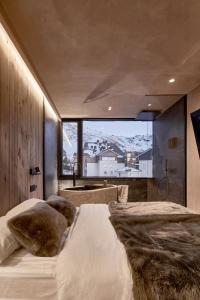 een slaapkamer met 2 bedden en een groot raam bij AticoNevado - Apartamento de lujo con vistas panoramicas 360 in Sierra Nevada