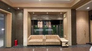 a lobby with a couch in a building at Hotel Sarovar Residency in Boisar +19 photos