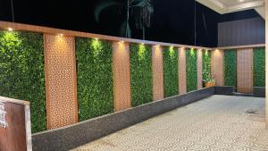 a green wall with lights in a building at Hotel Sarovar Residency in Boisar
