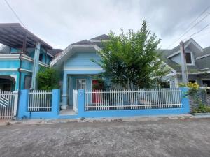 a blue house with a white fence at Homestay at 24 Laguna Bel-Air by Red Door House Rental in Santa Rosa