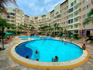 a large swimming pool in a resort with people in it at Thermas Paradise - 1 Quarto in Rio Quente
