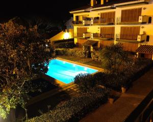 a swimming pool in front of a building at night at Apartamento con piscina L' Áncora in Calella de Palafrugell