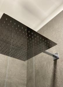 a black object on the side of a shower at Sonnenhof 1737 - Ferienzimmer & Apartments in Barbelroth