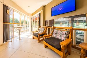 a living room with two chairs and a flat screen tv at Costanera Hotel in Villa Carlos Paz