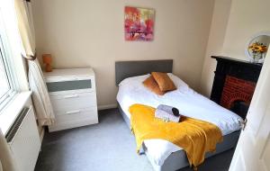 a small bedroom with a bed and a fireplace at Ruby Retreat - Entire House - WiFi - 4 Bed - Garden - Maidstone Town in Maidstone