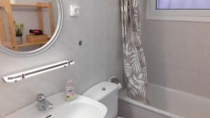 ein Badezimmer mit einem WC, einem Waschbecken und einem Spiegel in der Unterkunft Apartment Oli - Lloret de Mar in Lloret de Mar