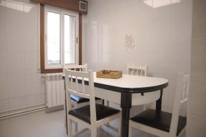 a dining room with a white table and chairs at Apartamento en Sigüeiro Rúa do Tambre in Sigüeiro