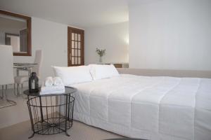 a bedroom with a large white bed and a table at Apartamento en Sigüeiro Rúa do Tambre in Sigüeiro