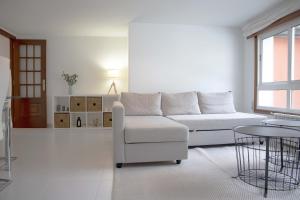 a white living room with a white couch and a table at Apartamento en Sigüeiro Rúa do Tambre in Sigüeiro