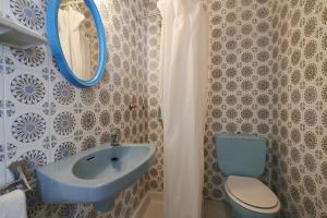 Un baño con un lavabo azul y un inodoro. en 1Auro - Calella de Palafrugell, en Calella de Palafrugell 11 fotos más