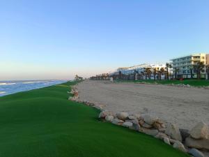einen Golfplatz am Strand neben dem Meer in der Unterkunft Porto Said Tourist Resort Luxury Hotel Apartment no390 in `Ezbet Shalabi el-Rûdi