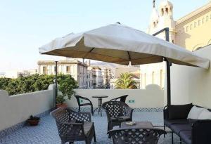 レッジョ・ディ・カラブリアにあるB&B La Terrazza Sul Duomoのパティオ(テーブル、椅子、パラソル付)