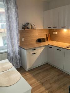 uma cozinha com armários brancos e um balcão de madeira em Reginka em Giżycko
