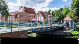 a bridge over a river in front of a building at Reginka in Giżycko