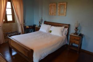 a bedroom with a bed with white sheets and a window at Pazo do Rio in A Coruña