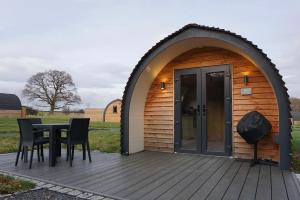 a gazebo with a table and chairs on a deck at Habberley Glamping Pods in Shrewsbury