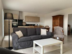a living room with a couch and a table at Le Muid in Congerville