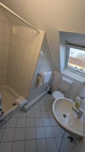 a white bathroom with a sink and a toilet at Europa City Apartment in Saarbrücken