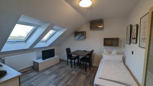 a room with a bed and a table with a desk at Europa City Apartment in Saarbrücken