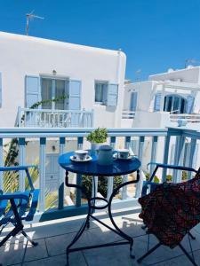 d'une table bleue et de deux chaises sur un balcon. dans l'établissement Aphrodite sunshine suite, à Mykonos