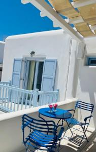 un tavolo blu e 2 sedie sul balcone di Aphrodite sunshine suite a Mykonos Città