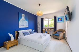 1 dormitorio con cama y pared azul en Maison Saint Paul en La Colle-sur-Loup