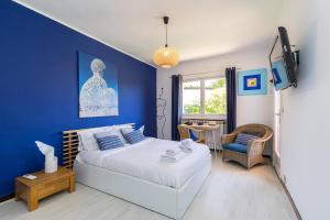 a bedroom with a bed and a blue wall at Maison Saint Paul in La Colle-sur-Loup